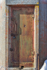 An old rusty lighthouse door. A door with a padlock.