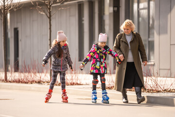 grandma teaches two granddaughters to roller skate