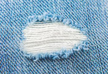 Ripped blue hipster jeans material. Destroyed denim Cloth texture. Close up.