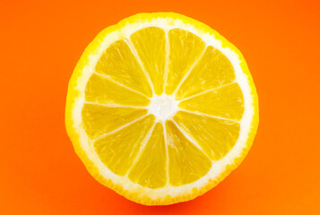 Fototapeta na wymiar Close up photo of lemon texture on the orange background. Fruit cut in half, inside, macro view. Minimalism, original and creative photo.