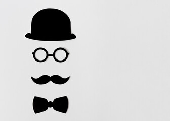 Elegant and fun black and white composition made of props appearing as a gentleman with mustache and glasses. Flat lay design with copy space.