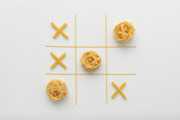 Flat lay creative and fun composition made of organic yellow pasta representing tic tac toe game