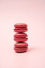 Bright oink french macaroons stacked on blush background