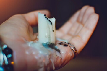 The woman holds an extinguished candle in her palm.