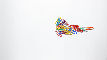 Stationery paper clips of different colors on a white background.