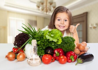 Little happy girl with raw vegetables