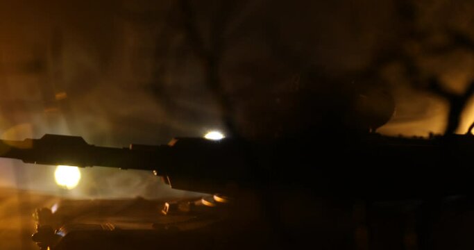 War Concept. Armored vehicle silhouette fighting scene on war foggy sky background at night. American tank moving in destroyed city. Slider shot