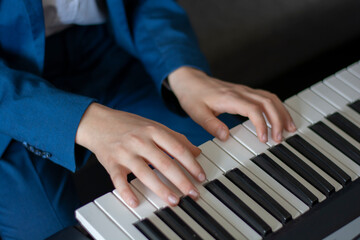 Obraz premium Young boy learning to play the piano. Boy's hands practise the piano. Close up. Detail.