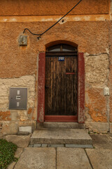 Old wooden door in orange old house in north Bohemia