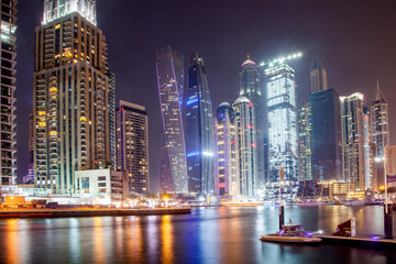 Fototapeta premium DUBAI, UAE - FEBRUARY 2018: View of modern skyscrapers shining in sunrise lights in Dubai Marina in Dubai, UAE.
