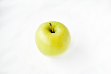 A bright green apple on a white background