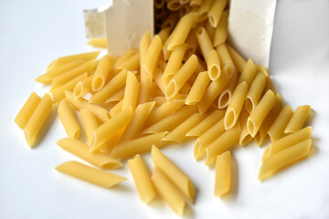 Yellow macaroni from a paper box on a white background