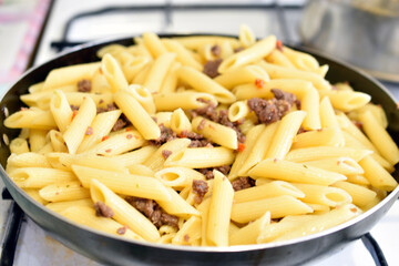 Freshly washed Italian pasta in a frying pan