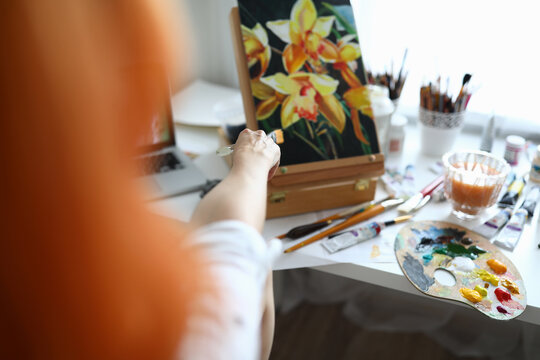 Close-up of talented female creating new picture of flowers