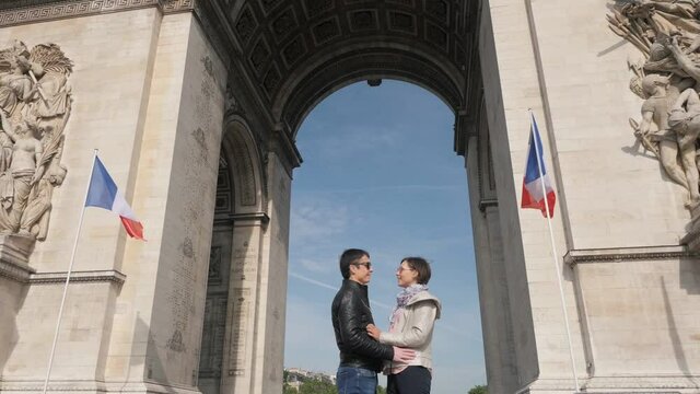 Couple hugs and joins hands under ancient Triumphal arch