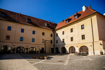 Fototapeta na wymiar Medieval gothic castle Kadan at royal city, Town fortification, fortress wall on sunny day, courtyard with arcades, historical building at the top of the hill, Kadan, Czech Republic