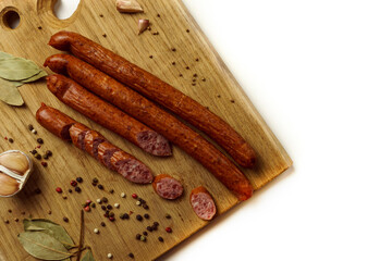 Sausages on a wooden board with garlic and spices. Space for text