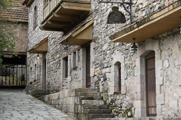 Fototapeta na wymiar Traditional stone and wooden buildings, now used as shops, eateries, and a hotel, in the Dilijan Historic Centre (Shaambeyan Poghots), Dilijan, Armenia