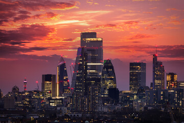 The modern skyline of the financial district City of London, United Kingdom, during a fiery sunset with red and orange sky