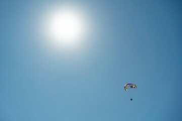 Water sport, parasailing. Mediterranean Sea, Turkey. Colorful parasail wing pulled by a boat in the sea water. Sea Scene With A Parachute And A Motor Boat, Side Turkey
