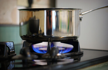 Pot on gas stove with flame and knobs