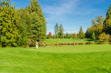 Fototapeta na wymiar Golf course with gorgeous green and pond