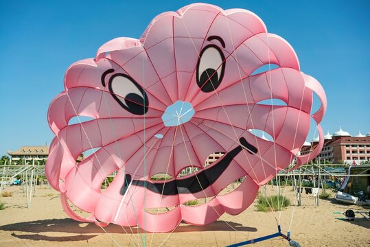 Water sport, parasailing. Mediterranean Sea, Turkey. Colorful parasail wing pulled by a boat in the sea water. Sea Scene With A Parachute And A Motor Boat, Side Turkey
