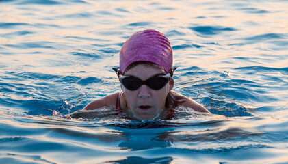 Female swimming breast stroke in pool