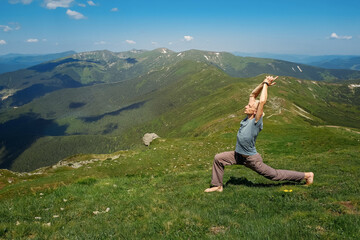 Naklejka na ściany i meble Strong man practicing yoga exercises under sky on mountain top