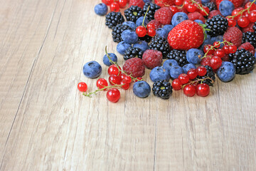 Fresh berries on wooden background, strawberry, blueberry, raspberry, blackberry and red currant