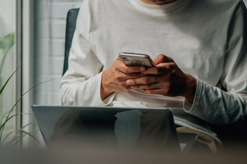 closeup of hands with mobile phone and computer