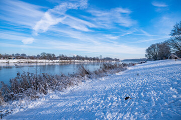 beautiful frozen river called werdersee at sunny warm white winter day with snowy dike in bremen