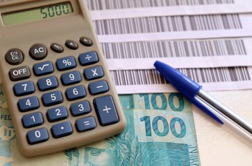 Bills to pay (Boleto system with Bar codes), calculator and Brazilian money. Economy concept.