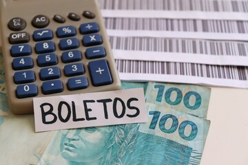 Bills to pay (Boleto system with Bar codes), calculator and Brazilian money.  Brazilian payment concept.  - obrazy, fototapety, plakaty