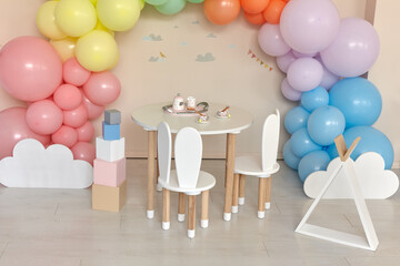 Small table and chairs with bunny ears in children's room interior