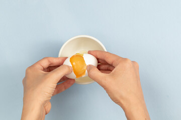 egg yolk in a hand on blue background