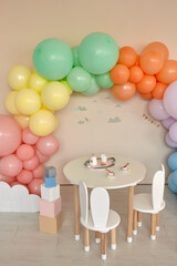 Small table and chairs with bunny ears in children's room interior
