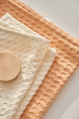 Handmade natural olive soap lies on a natural muslin towel. Composition in beige. View from above.