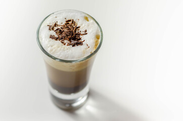 Coffee drink shot with a nutty note with fluffy milk foam, decorated with chocolate shavings