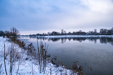 beautiful, almost frozen river called werdersee at cold white winter with snow in bremen