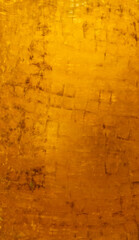 Vintage golden wall with matte paint texture with gilded effect, dark stains and scratches on surface.