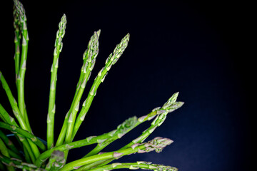 bunch of green asparagus on black background