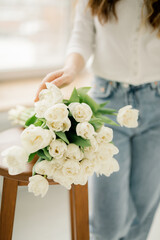 a bouquet of white tulips lies on a chair