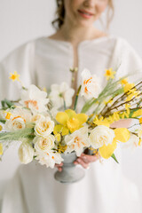 the bride in a white dress holds a bouquet of yellow flowers