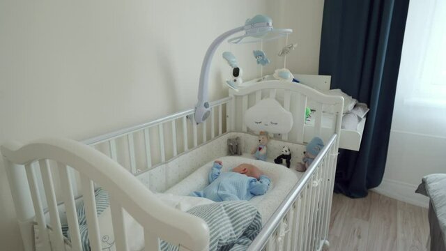 Adorable baby boy sleeping in a crib lying in baby pod nest newborn cocoon. High quality 4k footage