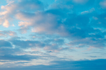 Naklejka na ściany i meble Blue sky with white-pink clouds.