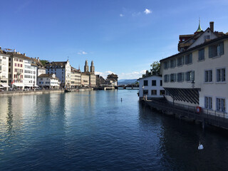 The Limmat River and the Limmatquai waterfront promenade in Zürich, Switzerland. The Grossmünster protestant church's towers can be seen in the background.