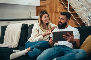 Couple using a digital tablet at home