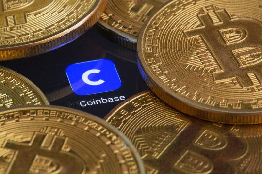 Coinbase logo on screen with Bitcoin coins. Ljubljana, Slovenia - April 06 2021