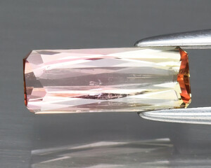 Natural gemstone bi-color tourmaline on the background Rectangular bi-color tourmaline